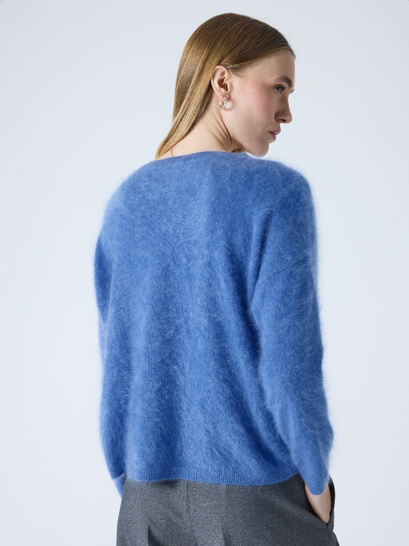 blue v neck jumper with long sleeves and fluffy texture rear view
