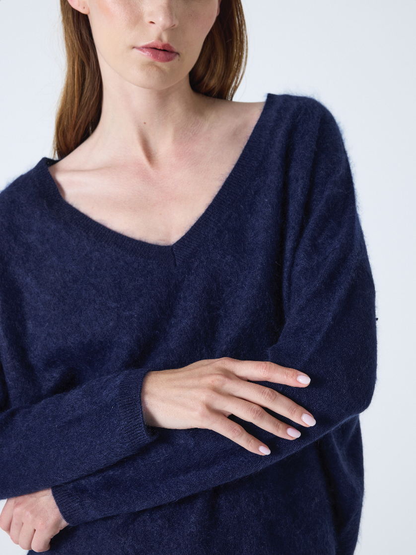 navy v neck jumper with long sleeves and fluffy texture close up