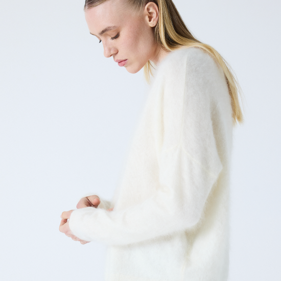 cream v neck jumper with long sleeves and fluffy texture side view
