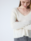 cream v neck jumper with long sleeves and fluffy texture close up