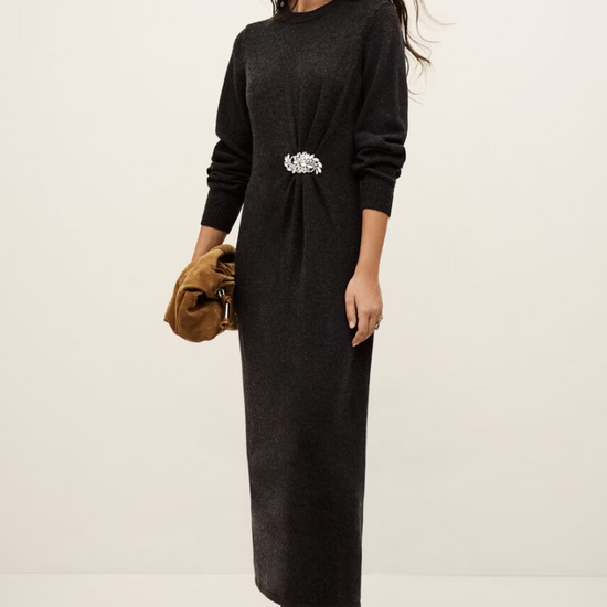 charcoal grey knitted long dress with round neck, ruche detailing with a statement crystal brooch and balloon sleeves model shot