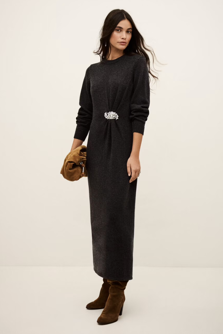 charcoal grey knitted long dress with round neck, ruche detailing with a statement crystal brooch and balloon sleeves model shot