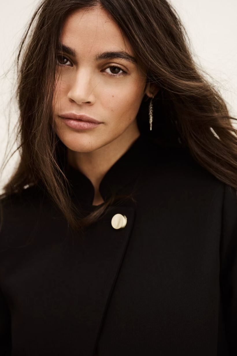 cropped black jacket with asymmetric placket and singular gold button from bash close up