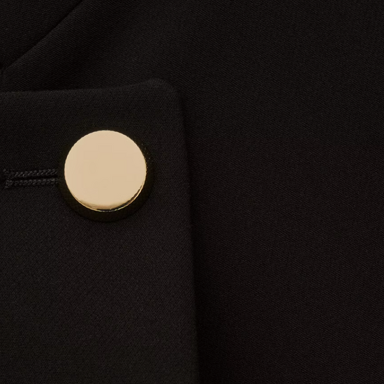 cropped black jacket with asymmetric placket and singular gold button from bash close up of fabric