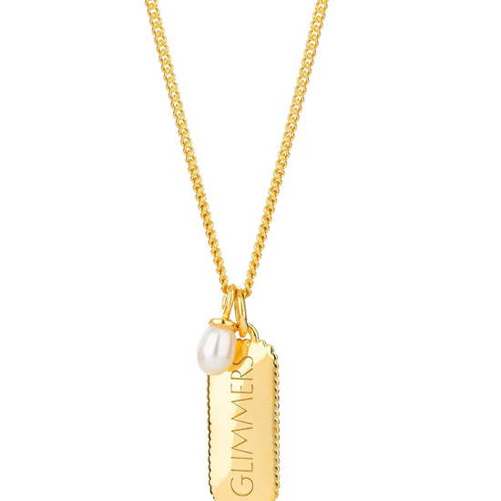 rectangular gold pendant with heart on one side and glimmer written on the other with pearl from claudia bradby reverse side