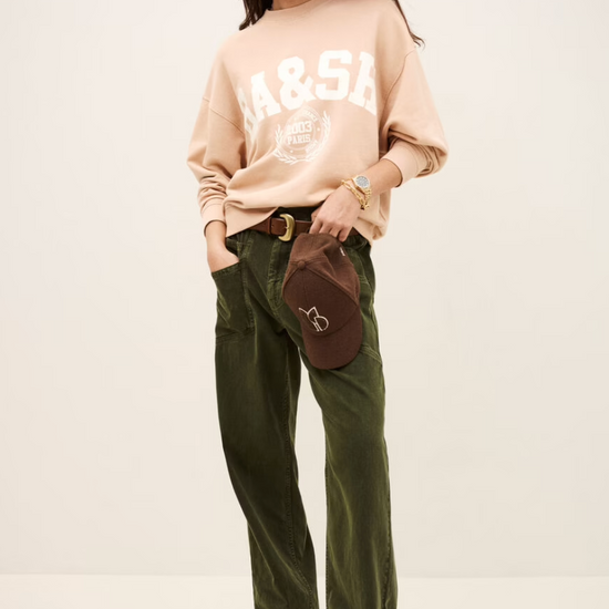 light pink long sleeve sweatshirt with white bash on the front model shot
