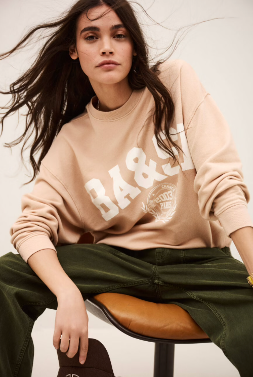 light pink long sleeve sweatshirt with white bash on the front model shot