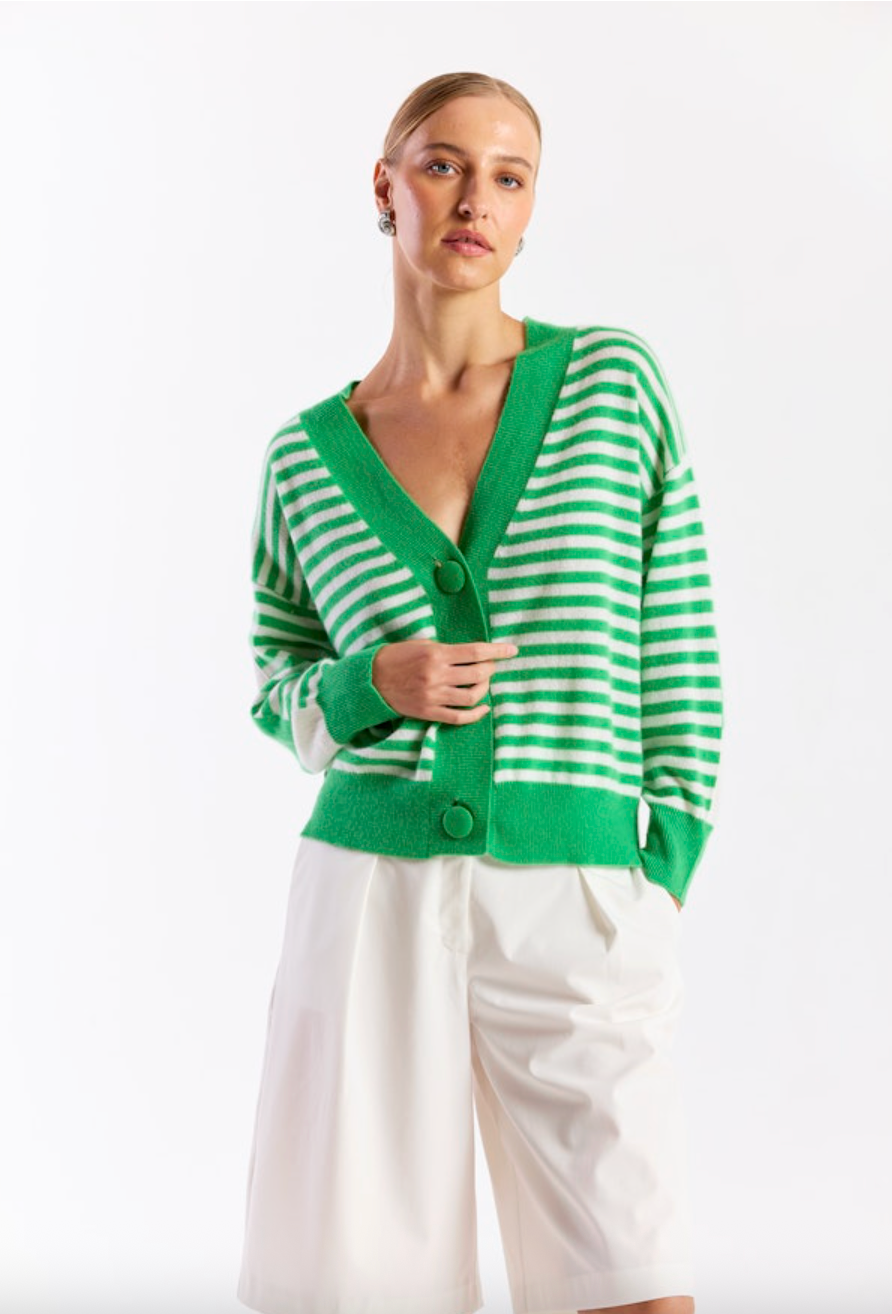 Woman wearing a green and white striped cardigan on a white background