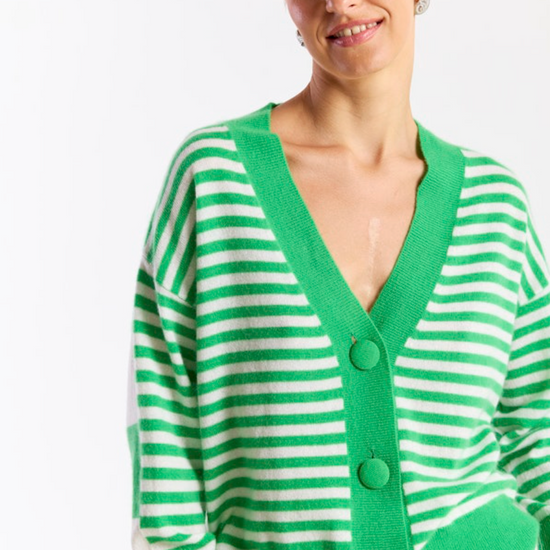 Woman wearing a green and white striped cardigan on a white background