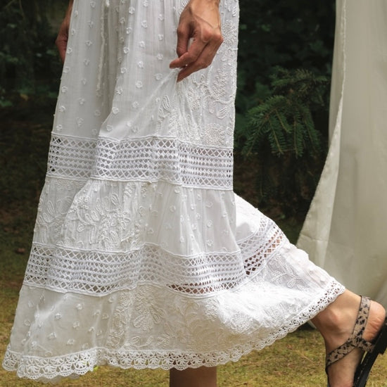 White lace dress with a blurred natural background