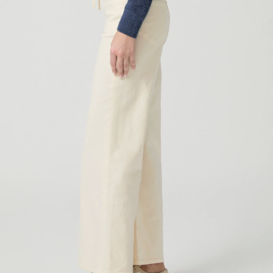 Cream jeans with drawstring side facing on a model on a white background 