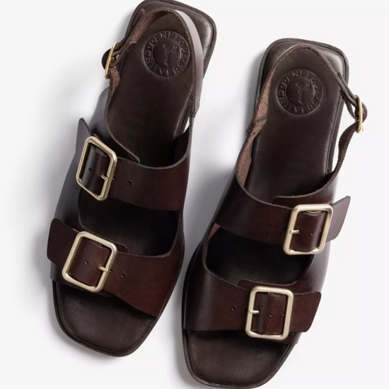 a pair of dark brown sandals on a white background