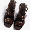 a pair of dark brown sandals on a white background