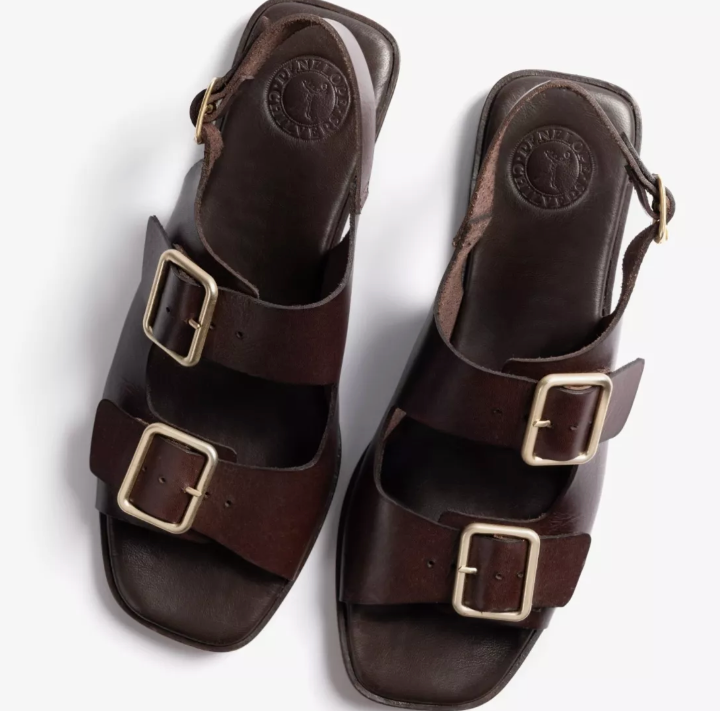 a pair of dark brown sandals on a white background