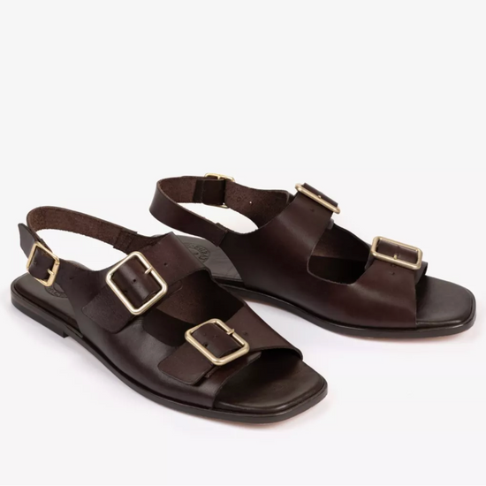 a pair of dark brown sandals on a white background