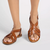 a pair of tan sandals on a model on a white background 