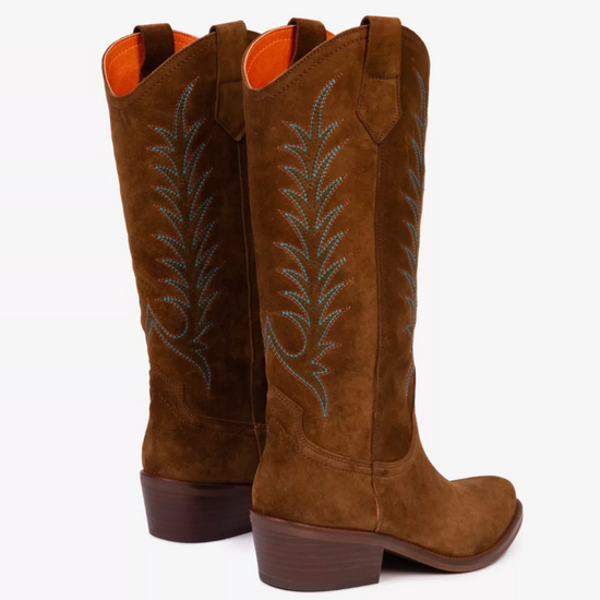 pair of tan suede cowboy boots on white background 