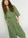 elbow length green shirt dress with belt and mid length model