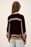 dark brown button down blouse with colourful paisley print from bash model model rear