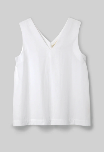 white v neck top on a light grey background