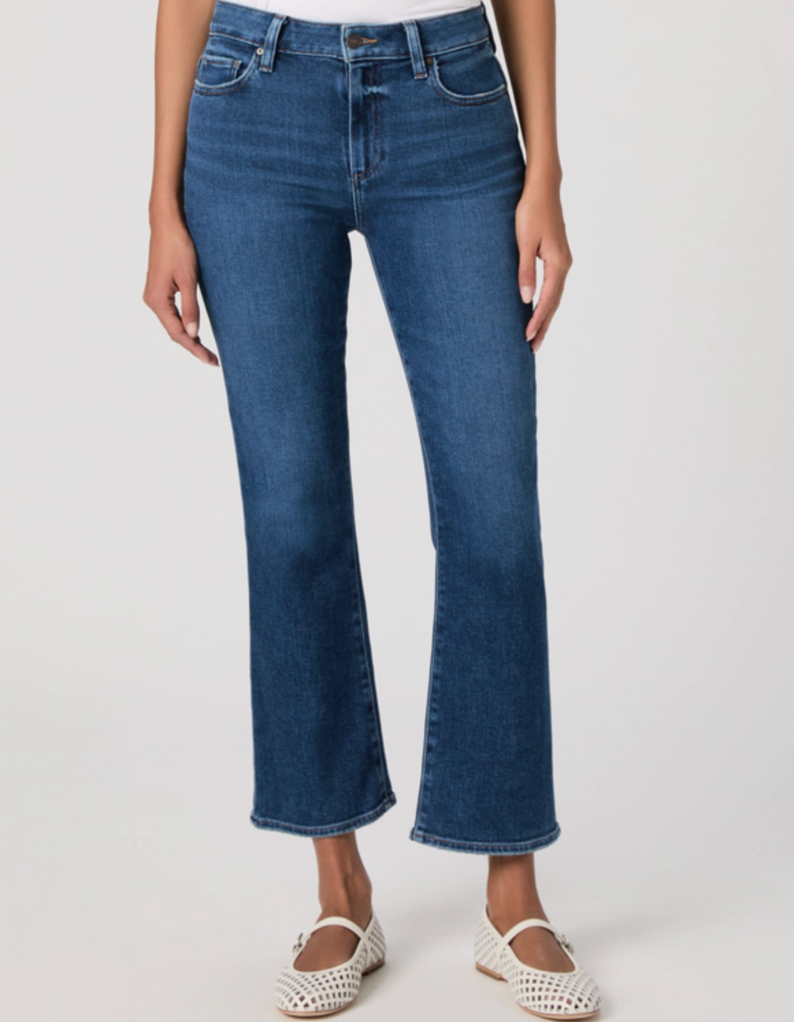 Blue jeans worn by a person on a white background