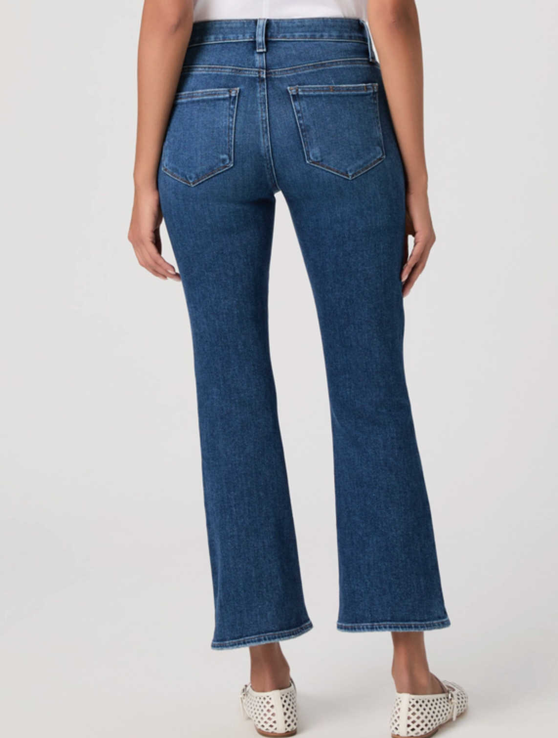 Blue jeans worn by a person on a white background