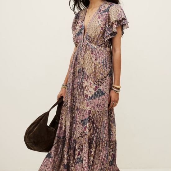 Woman wearing a floral dress holding a black bag on a white background