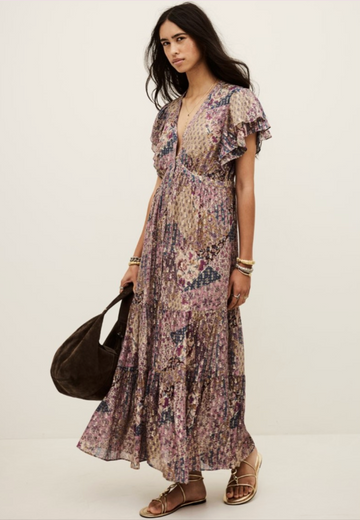 Woman wearing a floral dress holding a black bag on a white background