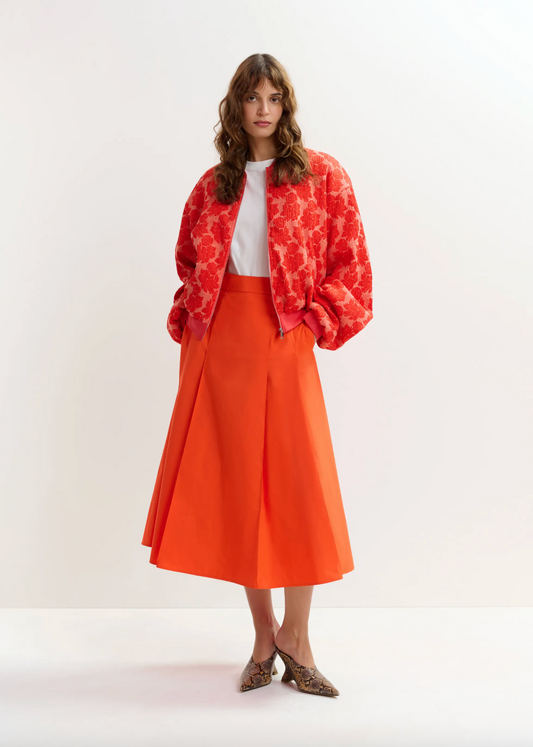 Bright orange midi skirt worn with bright zip through top
