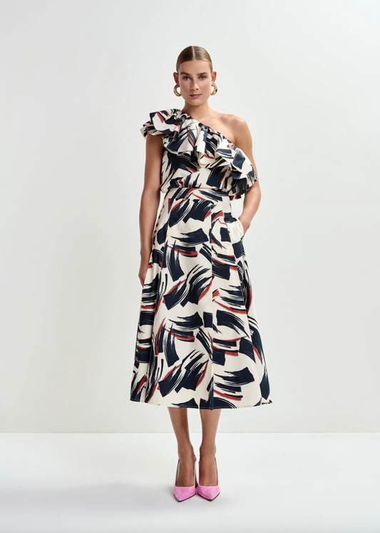 Woman wearing a one-shoulder patterned dress on a white background