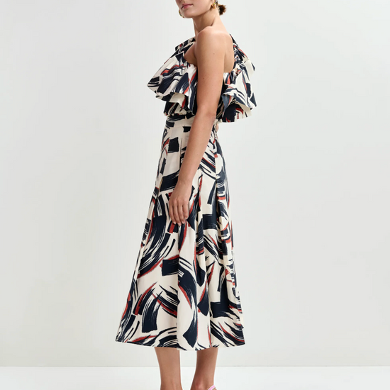 Woman wearing a patterned dress with pink shoes on a white background