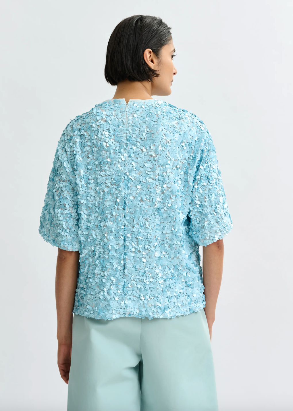 Rear view of pale blue sequin top