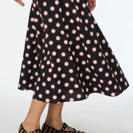 Black printed skirt worn with flat woven shoes