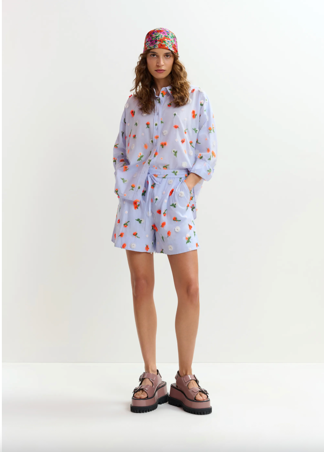 Woman wearing a light blue floral dress with a white background