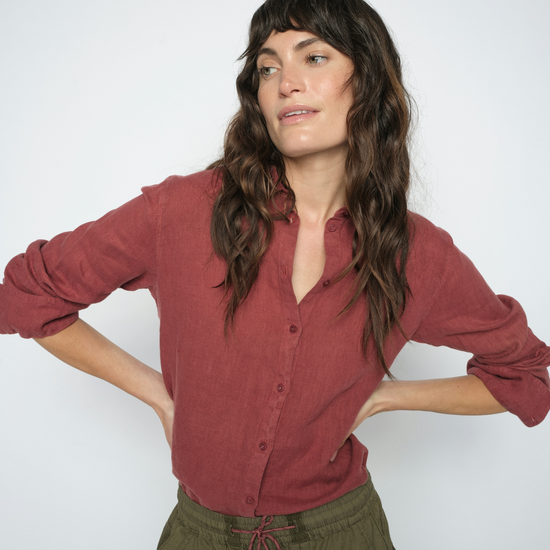 model wearing a red linen shirt and green trousers on a white background