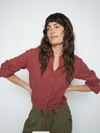 model wearing a red linen shirt and green trousers on a white background