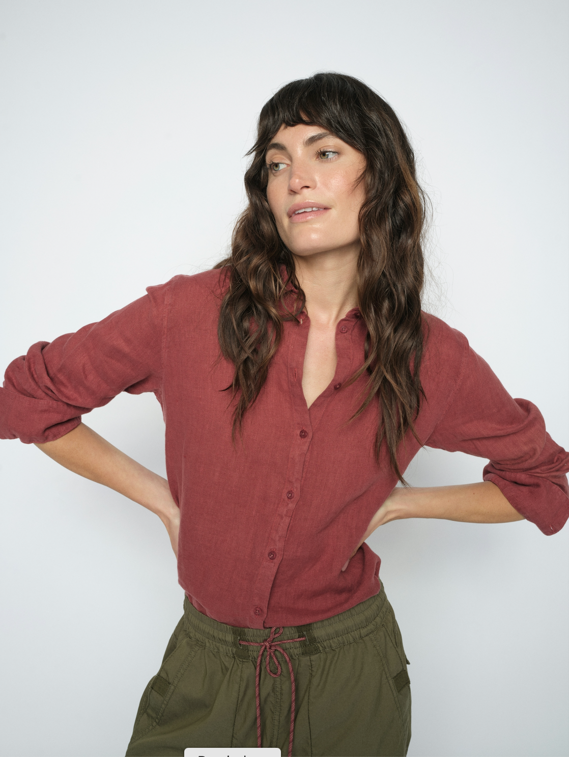 model wearing a red linen shirt and green trousers on a white background