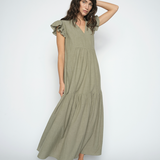 Model shot wearing a green floaty dress on a white background 