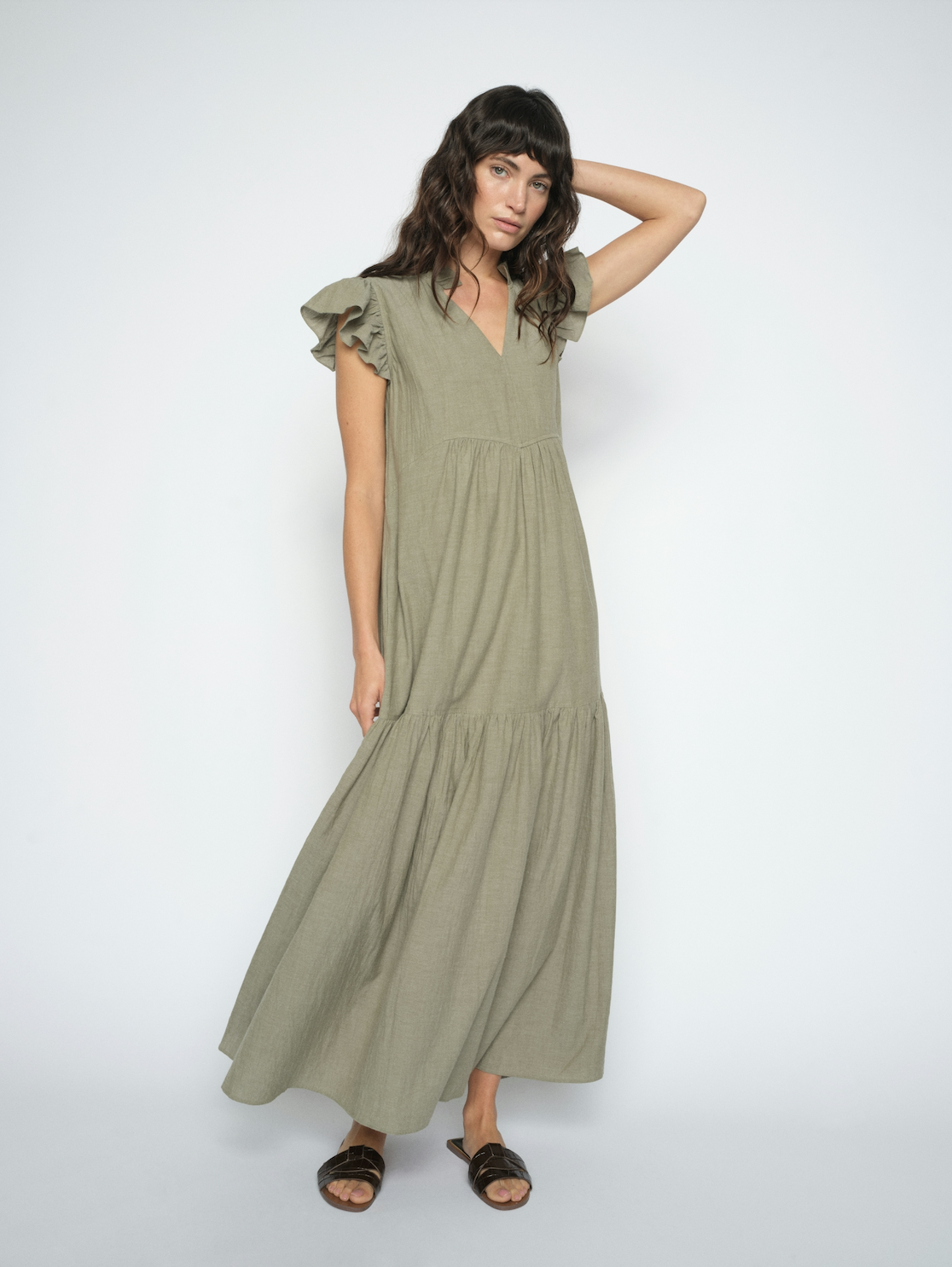 Model shot wearing a green floaty dress on a white background 