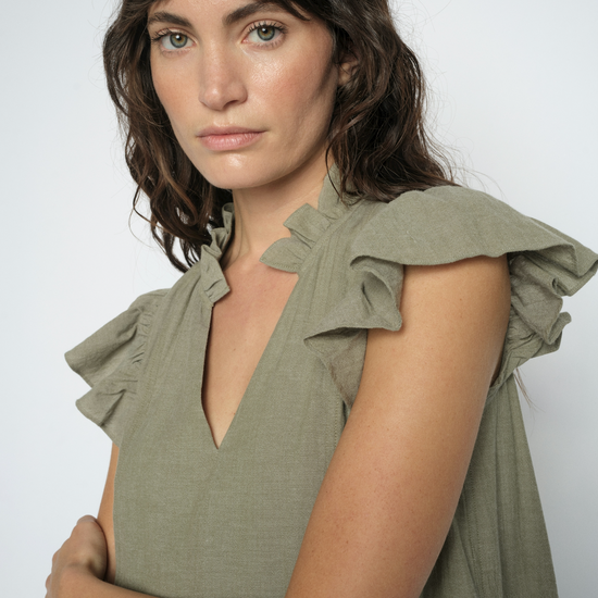 Close up of model wearing a green dress on a white background