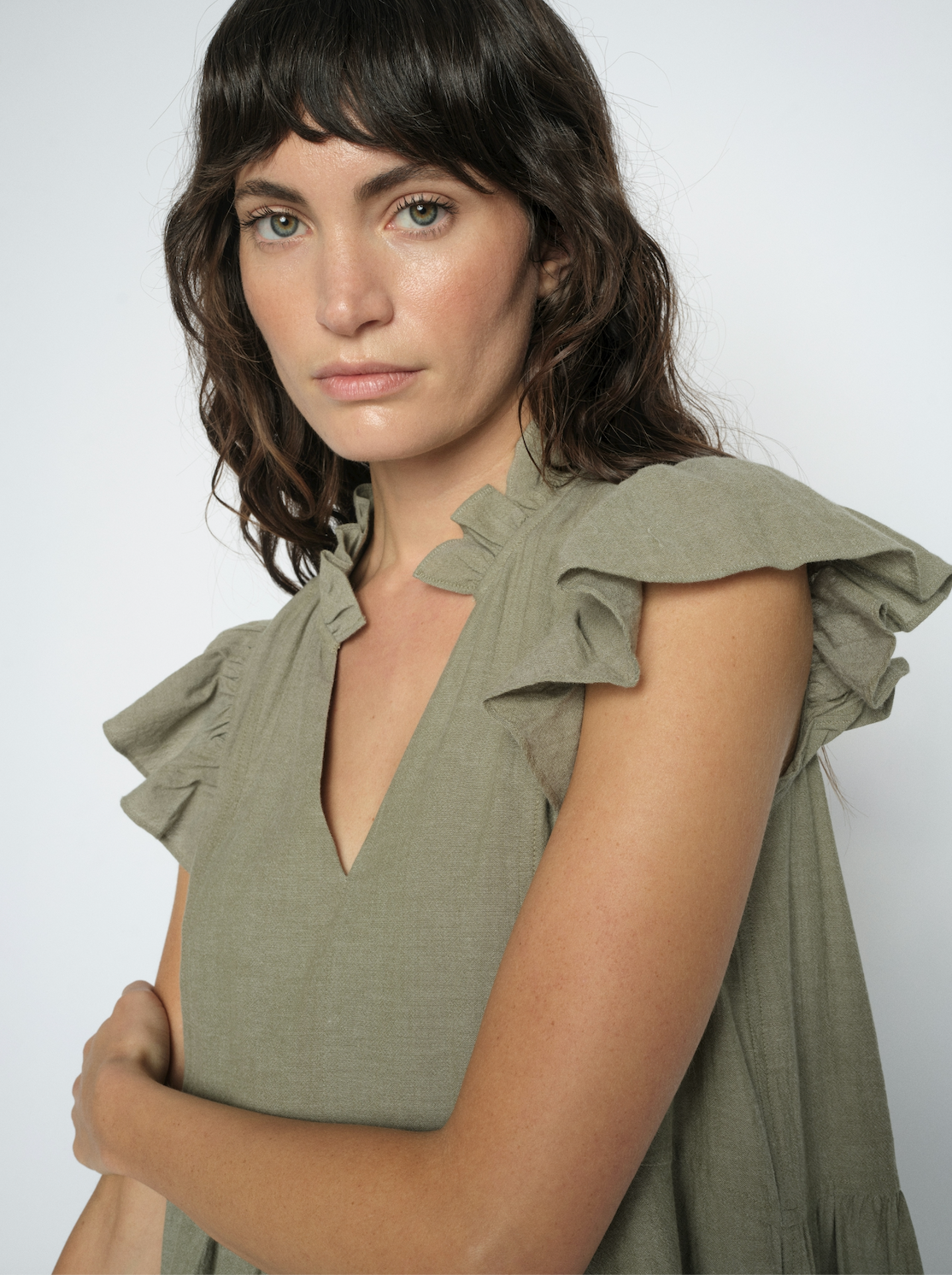 Close up of model wearing a green dress on a white background