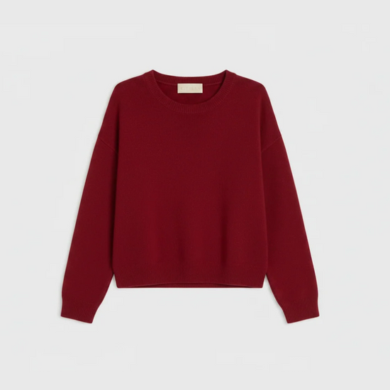 A long-sleeve crewneck sweater in a deep burgundy red, laid flat against a light gray background.