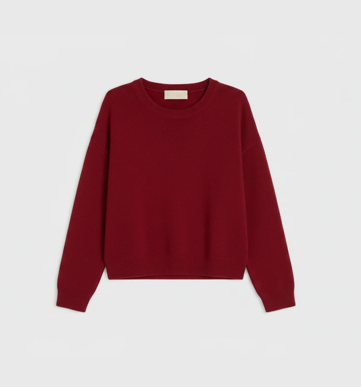 A long-sleeve crewneck sweater in a deep burgundy red, laid flat against a light gray background.