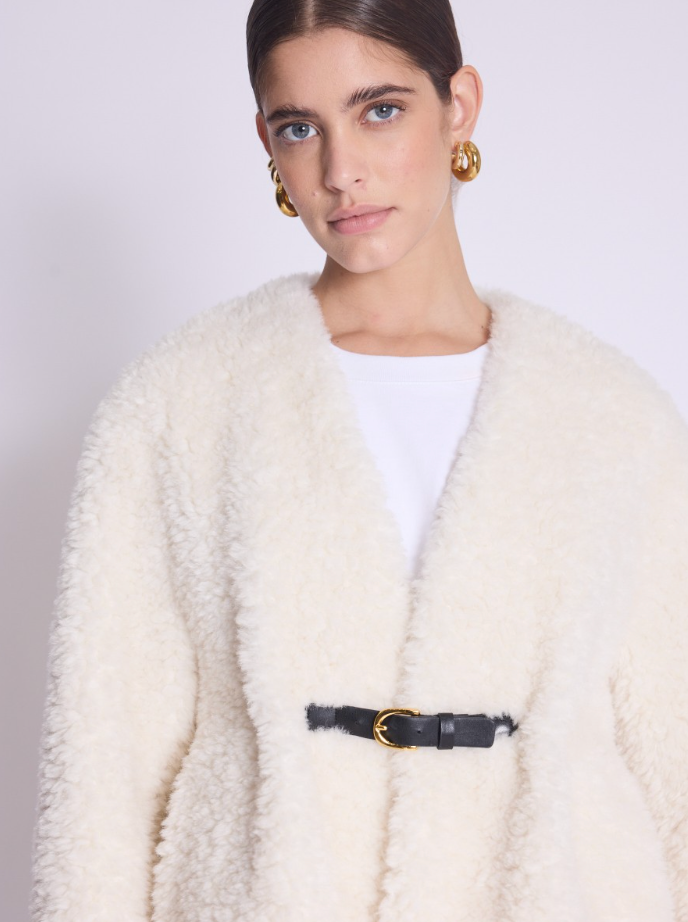 white faux fur cropped jacket with black buckle fastening and v neck 