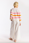 Person wearing a striped sweater and white pants on a white background