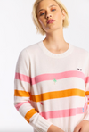 Woman wearing a colorful striped sweater with small embroidered designs on a white background