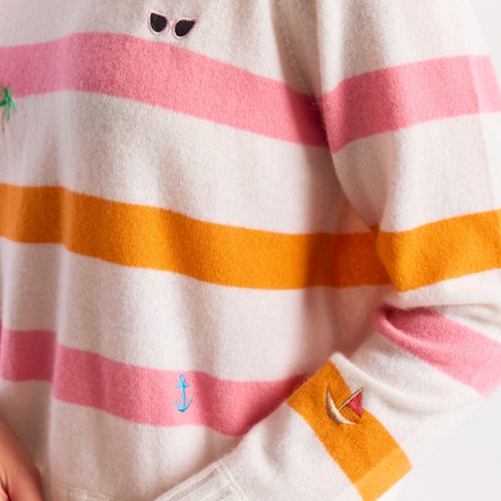 Close-up of a striped sweater with a brand tag, featuring pink, orange, and white colors.