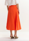 Person wearing an orange skirt and white top on a white background