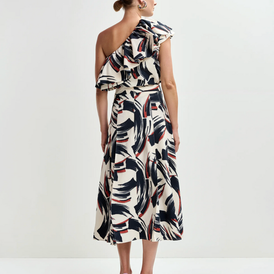 Woman wearing a one-shoulder dress with a geometric pattern on a white background