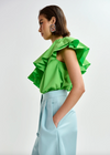 Side view of bright green top worn with blue trousers